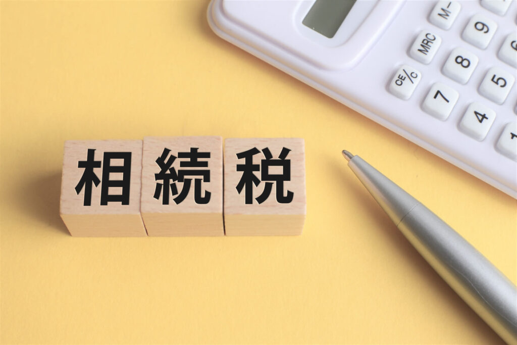 電卓とペンの左にある「相続税」の文字が入った木製ブロック